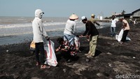 Warga ramai-ramai membersihkan tumpahan minyak di pesisir pantai Kabupaten Karawang, Jawa Barat, Rabu (24/7/2019).