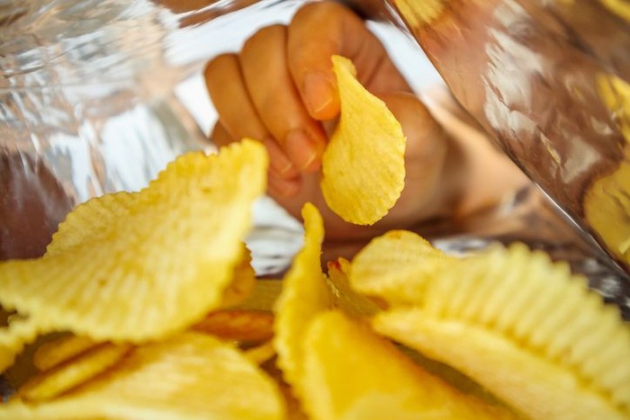 Close up of mens hand grabbing chips