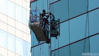 Tanpa helm dan alat keselamatan diri lainnya, para pekerja membersihkan gedung-gedung bertingkat di Jakarta.