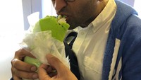  Ini nih pose tak sabar sekaligus lucu dari Kumail saat berusaha menyantap burrito berwarna hijau, yang berukuran besar saat di dalam pesawat. Foto: Istimewa