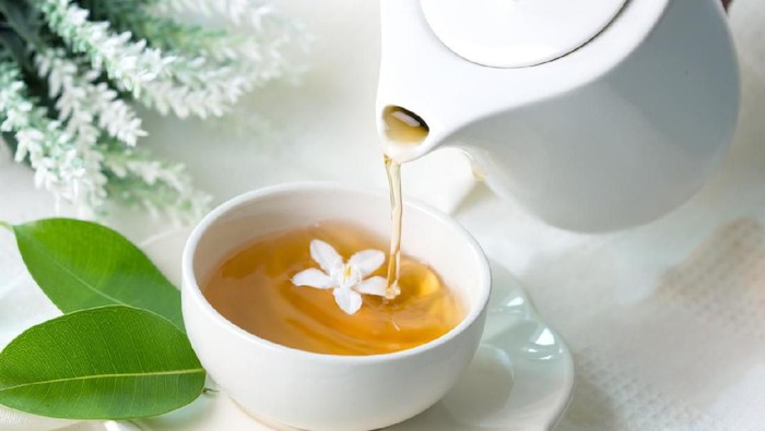 Close up pouring hot jasmine tea in a white tea cup , Tea ceremony time concept