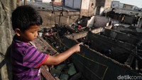 Seorang anak menunjukkan sisa-sisa bangunan pascakebakaran melanda kawasan Rawa Badak di Jakarta Utara, Jumat (26/7/2019).