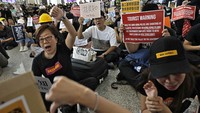 Dalam aksinya, para demonstran yang duduk di area penjemputan rombongan di dalam area bandara ini meneriakkan slogan protes seperti hanya ada tirani, tidak ada perusuh dan ayolah, Hong Kong yang diucapkan dalam bahasa Kanton. Foto: AP Photo/Vincent Yu