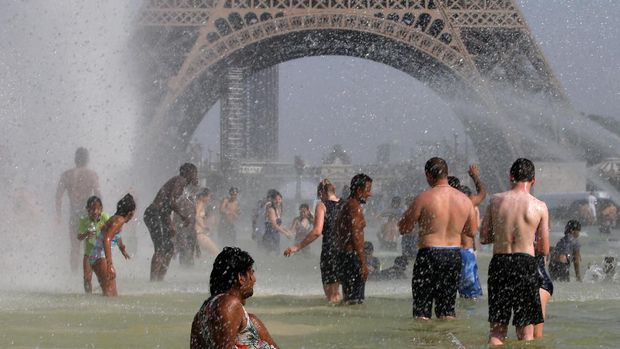People cool off in the Trocadero fountains across from the Eiffel Tower in Paris as a new heatwave broke temperature records in France, July 25, 2019. REUTERS/Pascal Rossignol
