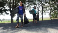 Dua warga yang telah selesai mencuci pulang ke rumahnya.