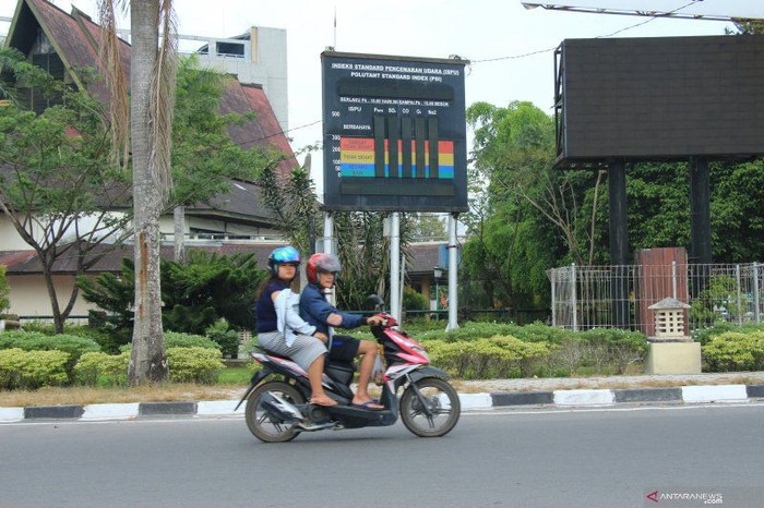 Warga Kota Palangka Raya saat melintas di depan monitor tampilan ISPU di Bundaran Besar Kota Palangka Raya, Kamis (18/7/19) (Foto Antara Kalteng/Rendhik Andika)