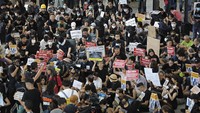 Para demonstran membawa poster bertuliskan slogan protes mereka agar bisa dilihat warga asing yang berkunjung ke kota ini. Mereka menargetkan para wisatawan asing untuk memberitahu situasi terkini di Hong Kong juga soal tuntutan mereka. Foto: AP Photo/Vincent Yu