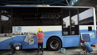 Sejumlah petugas sedang melakukan perawatan bodi bus TransJakarta.