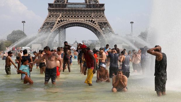 People cool off in the Trocadero fountains across from the Eiffel Tower in Paris as a new heatwave broke temperature records in France, July 25, 2019. REUTERS/Pascal Rossignol