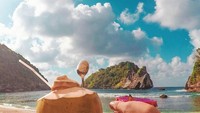 Ada buah naga dan es kelapa yang menemani Pandhu bersantai ketika berlibur di pantai yang indah. Foto: Instagram @backpackertampan
