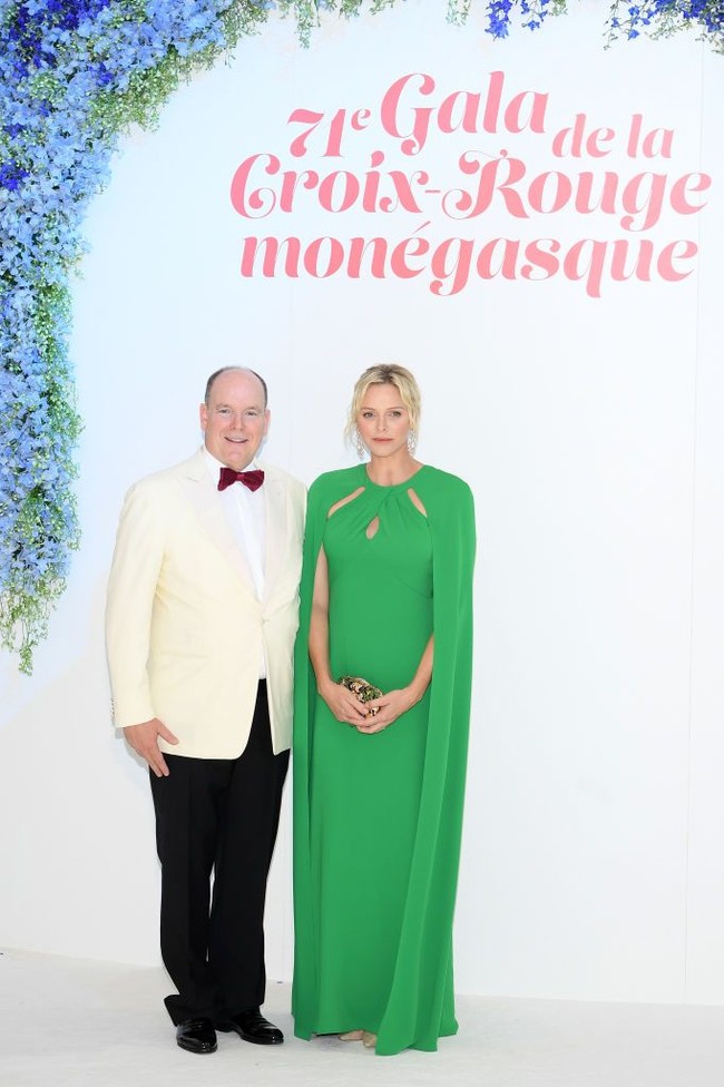 Tidak ketinggalan clutch keemasan dengan aksen hijau dan heels berwarna nude.  Foto: Getty Images