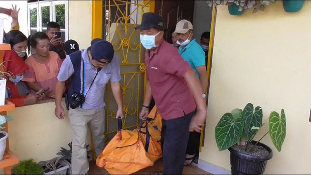 Polisi membawa jenazah korban.