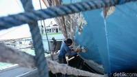 Petugas tengah mengecat kapal di pelabuhan Paotere.