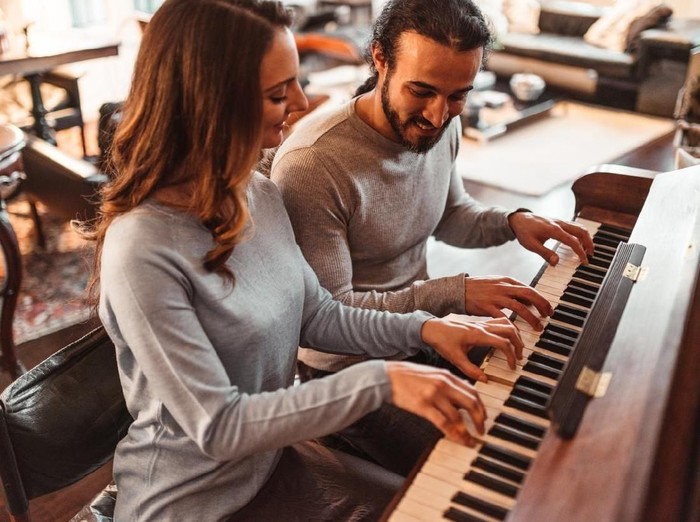 couple playing piano in a lux apartment