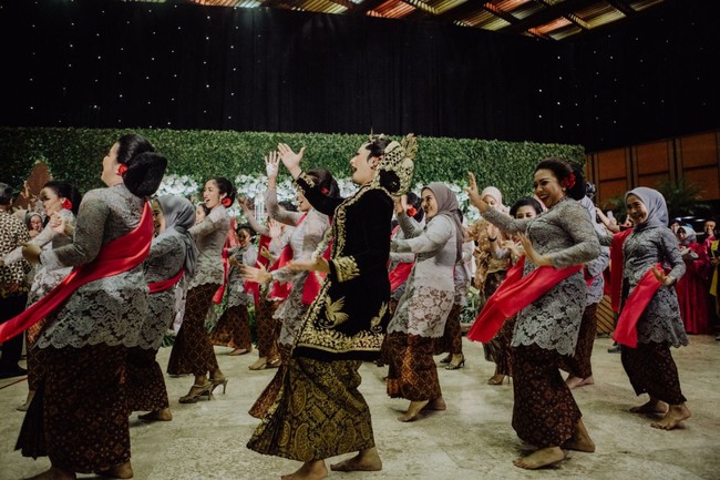 Berbalut pakaian busana pengantin adat Jawa lengkap dengan konde dan kembang goyang di kepalanya, Okti turun dari pelaminan dan menari penuh energik bersama among tamu dan para tamu. Foto: dok. @maknafoto