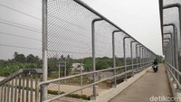 Seorang pengendara terlihat sedang melintasi jembatan penyeberangan orang (JPO) yang berada di atas ruas Tol Cinere-Jagorawi (Cijago), Kota Depok, Jawa Barat , Selasa (30/7/2019).
