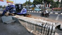 Sebuah alat berat turut dikerahkan untuk membantu pekerjaan tersebut.