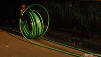 Pekerja tengah menggulung kabel.