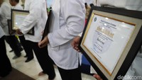 Anies memberikan sertifikat kelayakan kepada para Penyembelih hewan dan para petugas kesehatan hewan kurban.