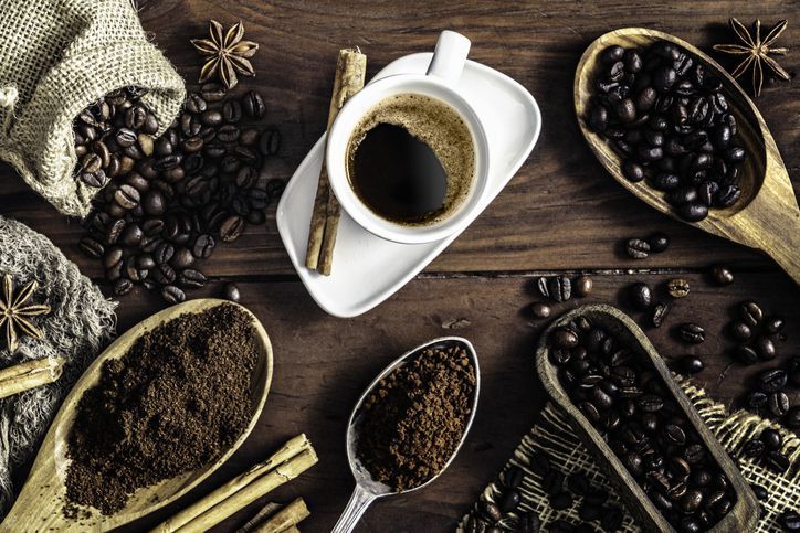 Coffee cup and beans on wooden table. Top view.