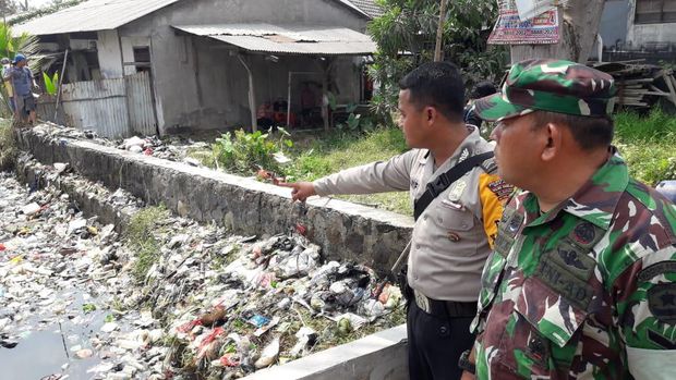 Aparat TNI dan Polri ikut turun ke Kali Bahagia untuk membersihkan sampah yang menumpuk.