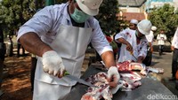 Terlihat para petugas mengenakan peralatan yang lengkap saat menyembelih hewan.