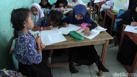 Bahkan satu meja harus digunakan untuk tiga orang siswa.