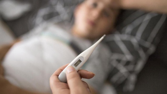 termometer Close-up Of Hand Checking Girls Ear With Digital Thermometer