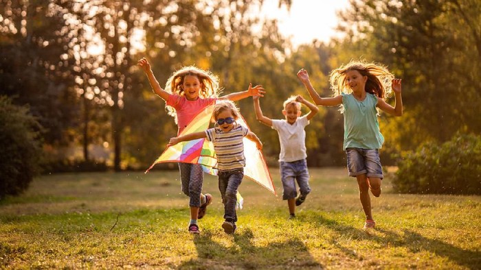 Asian and mixed race happy young kids running playing football together in garden. Multi-ethnic children group, outdoor sport exercising, leisure game activity, or childhood fun lifestyle concept