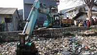 Satu unit ekskavator dikerahkan untuk mengeruk sampah yang menghampar di Kali Bahagia.