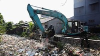 Ekskavator terus mengeruk sampah yang memenuhi Kali Bahagia.