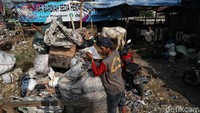 Pemulung mengumpulkan barang-barang bekas yang masih bisa dijual.