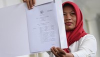 Baiq Nuril menunjukkan kepada awak media salinan petikan Keppres Amnesti di Istana Bogor.