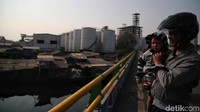 Terlihat seorang warga mengajak sang anak melihat suasana pabrik dari jembatan.