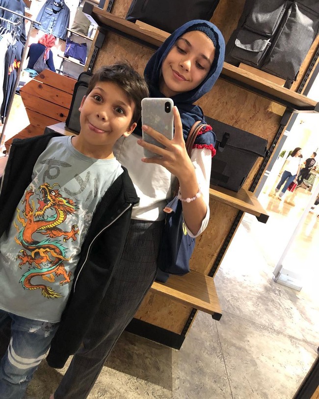 Isabel Azhari berfoto di depan cermin bersama dengan adiknya Lennon Tramp. Isabel terlihat memakai pashmina warna navy tanpa jarum pentul. Foto: dok. instagram @isabel.azhari