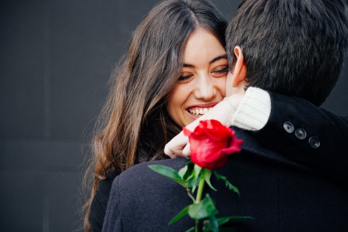 Tanda Siap Jatuh Cinta Lagi Precious moments of love. Close up portrait of handsome bearded guy kissing his girlfriend in cheek while she hugging him. Lady closing eyes with pleasure and smiling