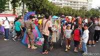 Petugas Satpol PP juga berjaga di sepanjang jalan yang dipakai untuk kegiatan CFD. Petugas sesekali menegur para PKL dan partisipan yang tengah menggelar dagangan ketika melewati batas yang diperbolehkan. (Foto/ Farih/detikcom)