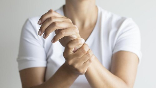 Woman holding wirst.