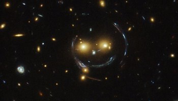 Gambar mirip mimik wajah yang tengah tersenyum ini adalah klaster galaksi bernama SDSS J1038+4849. Foto: NASA