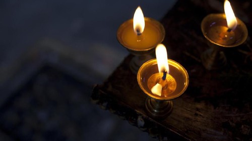 A candle flame inside of a mason jar on a work bench