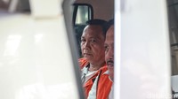 Effendi Hatta memasuki mobil yang akan membawanya ke tahanan.