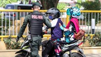 Seorang personel Polisi Wilayatul Hisbah (Polisi Syariat Islam) tengah mengehentikan pengendara motor yang duduk mengangkang saat dilakukan penertiban di Lhokseumawe, Aceh, Senin (5/8/2019).
