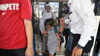 Penumpang turun dari bus.