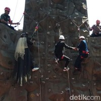 Saat hari pernikahannya, Nita yang berhijab memakai gaun pengantin muslimah dilengkapi dengan veil. Sedangkan Subandriyo mengenakan setelan jas hitam dan kemeja putih. Tak lupa keduanya memakai helm dan tali pengaman saat penghulu menikahkan mereka di ketinggian empat meter. Sang penghulu yang menikahkan mereka pun ikut panjat dinding lengkap dengan memakai helm dan tali pengaman. Foto: Eko Susanto/detikcom