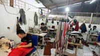 Para pekerja menyelesaikan penggantian kulit jok mobil di Classic Car Interior.
