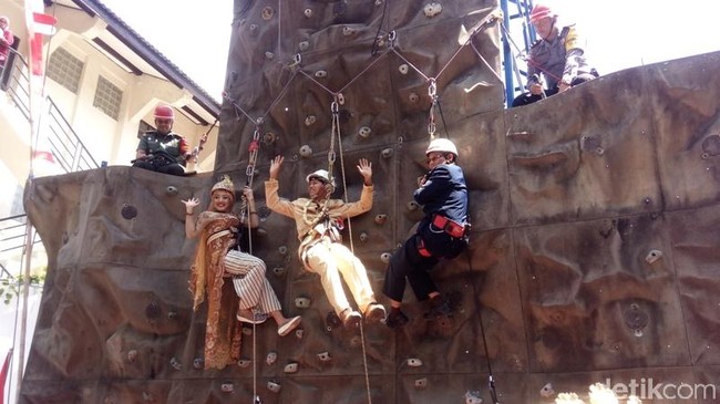 Prosesi pernikahan pasangan bernama Subandriyo dan Nita regina Mutiara Kasih menjadi viral karena begitu unik. Subandriyo dan Nita melakukan akad nikah di atas dinding panjat tebing pada Selasa (6/8/2019) di Universitas Muhammadiyah Malang. Keduanya bergelantungan di dinding panjat tebing saat penghulu yang juga ikut memanjat tebing, menikahkan mereka. Foto: Eko Susanto/detikcom