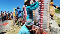 Botol-botol air mineral ukuran 1,5 liter itu terlebih dulu dirangkai menggunakan kawat ukuran kecil atau yang sering disebut kawat blendrat. Selanjutnya ditempelkan pada rangka piramida yang dibuat dari bambu. Di puncak piramida, ditancapkan bendera merah putih. Begitu pula di salah satu sisinya, juga dipasang bendera merah putih panjang (Ragil/detikcom)