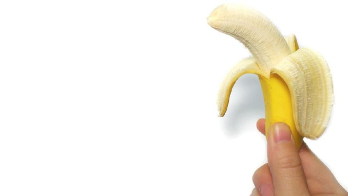 yellow banana and the hand in the white background