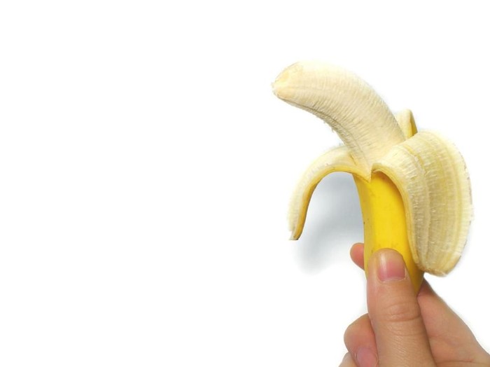 yellow banana and the hand in the white background