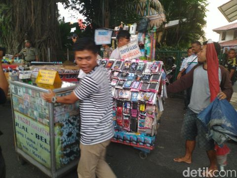 PKL mendorong barang dagangannya setelah ditertibkan petugas